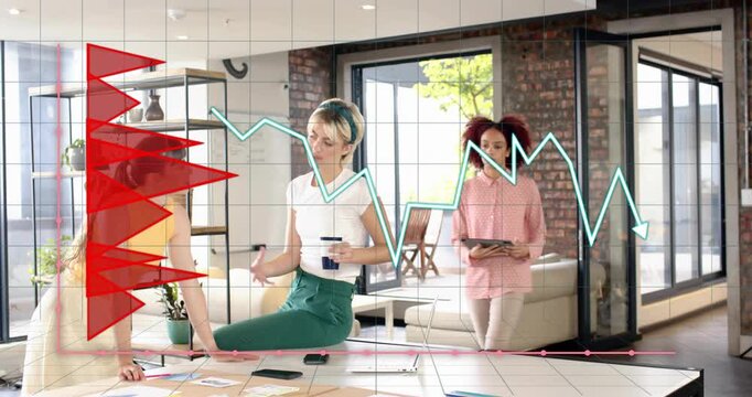 Cyan line chart overlaying, three women sorting notes and gesturing with tablet, planning marketing