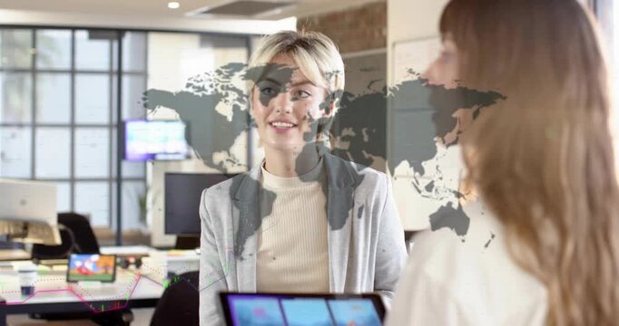 Center woman with mug talking as right peer showing tablet, sparking market charts for decisions