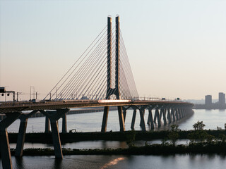 Obraz premium Cable stayed bridge over St Lawrence River at golden sunrise near Montreal and Brossard, Canada. g.