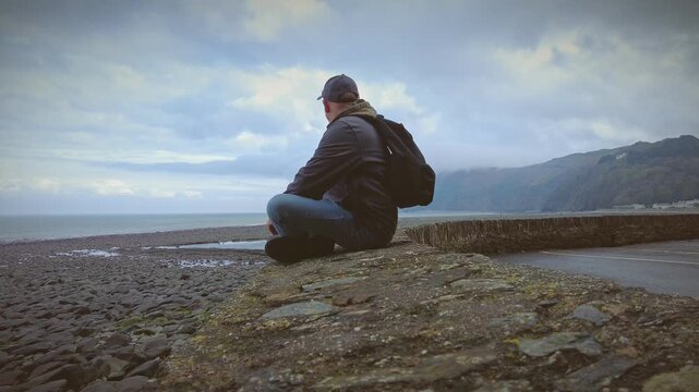 A hiker rambler tourist enjoys the delights of the North Coast of Devon in England via the South West Coastal Path.