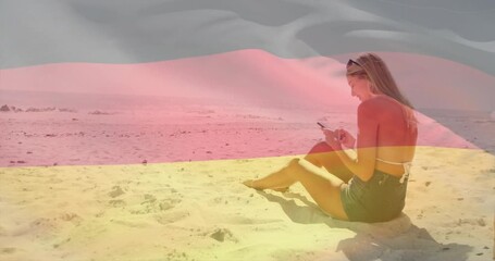 Woman tapping smartphone on beach, scrolling travel tips as sheer flag overlay waving across her