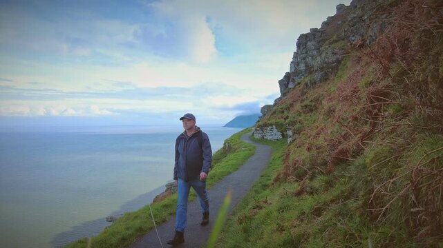 A hiker rambler tourist enjoys the delights of the North Coast of Devon in England via the South West Coastal Path.