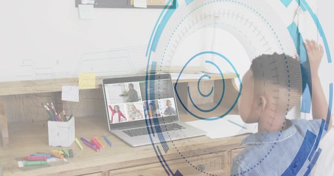 Boy raising hand to answer while teacher calling in online class, laptop overlay growing over desk