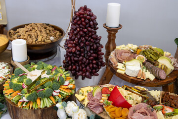Various charcuterie dishes with a tree made of grapes.