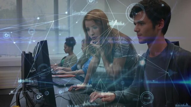 Woman leaning over man pointing at monitor in tech lab, guiding while animated nodes marking charts