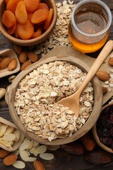 Making granola. Oat flakes, dried fruits and other ingredients on wooden table, flat lay