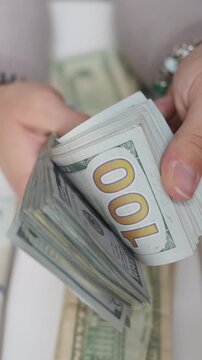 vertical screen quick finger movements sorting and counting currency, closeup of hands organizing and counting paper currency rapidly, rapid hand motions as seller prepares cash and change