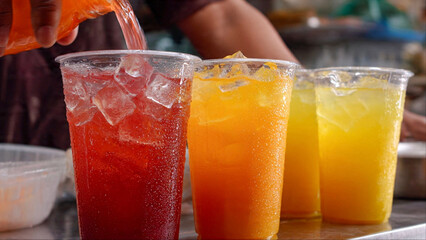 Refreshing fruit drinks being poured, colorful and thirst quenching