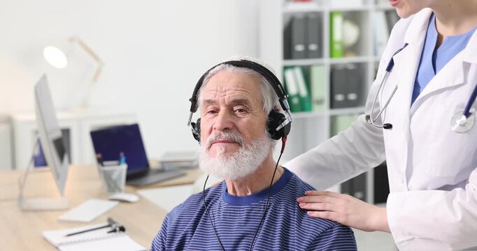 Hearing test. Doctor adjusting patient's audiometric headphones in clinic, closeup