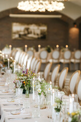 Elegant Wedding Reception Table Decor with Wildflower Centerpieces, Crystal Glassware, and Candlelight in a Softly Lit Luxury Banquet Hall