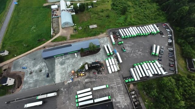 drone depot overview, aerial photograph showcasing transportation hub with vehicles and buildings, unmanned aerial perspective revealing organized fleet operations at industrial logistics