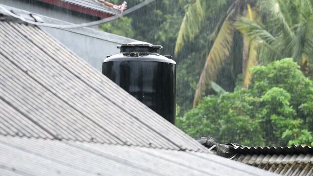 Black water tank place on the top of bilding under the rain