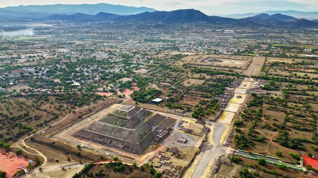 Aerial drone view of the ancient Teotihuacan pyramids with the surrounding Mexican town and mountain landscape