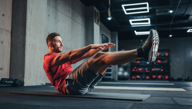 Man Doing V-Ups Exercise on Mat in Gym for Core Workout