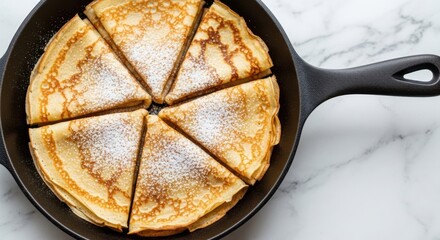 Classic Cut Crepes or Pancakes Dusted with Powdered Sugar in a Cast Iron Skillet , Breakfast or Dessert Top View
