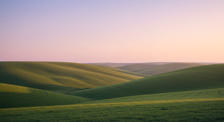 Obraz premium Smooth Rolling Green Hills at Sunset, Peaceful Palouse Landscape in the Evening Light, Soft Pastel Sky Over Undulating Green Terrain, Tranquil Rural Vista in Summer, Minimalist Landscape of Hills and 