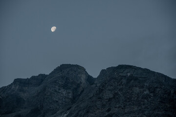 Obraz premium Moon Begins To Set Over Rocky Ridge In Glacier