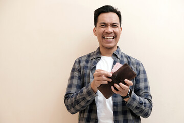 Southeast Asian man wearing flannel shirt standing and smiling expression happy with holding leather wallet, on white isolated background.
