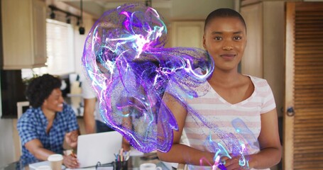 Standing woman in pink-tee clasping in kitchen with laptop, mugs and purple hologram, copy space