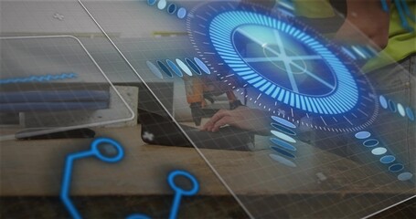 Typing two men wearing hi-vis vest leaning on laptop at workbench with AR circular UI overlay