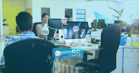 Working colleagues wearing business typing at open-plan office with monitors and 58 alert