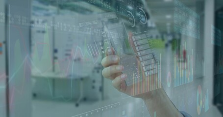 Holding smartphone, single hand with shirt cuff displaying holographic financial charts in office