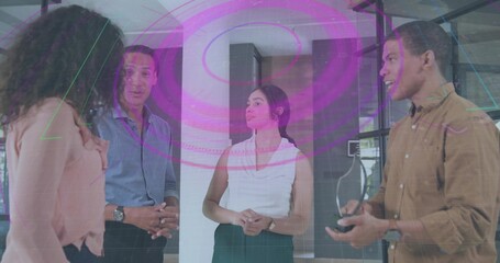 Talking team in business attire standing in office, man holding smartphone with magenta AR graphics