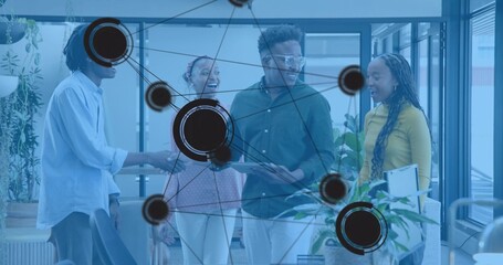 Discussing team in casual business holding tablet and folder in modern office, network overlay