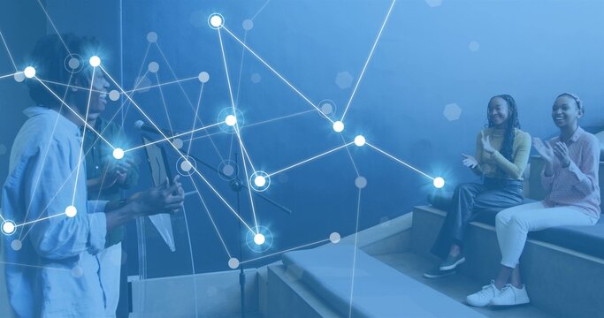 Playing female guitarist in light button-up and male singer at tiered seating, with acoustic guitar