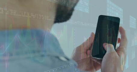 Holding bearded man in blue shirt viewing stock charts on smartphone in office, ticker overlays