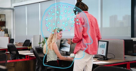 Talking pair in business wear holding phone, viewing charts with blue brain graphic at office desk