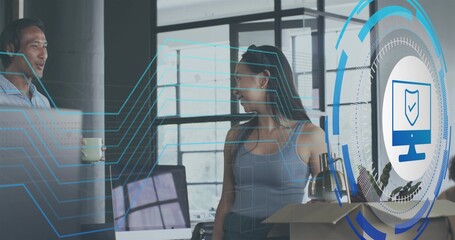 Talking woman wearing sleeveless top and trousers in office bay, with monitors and security overlay