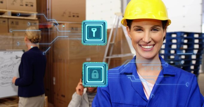 Smiling woman in yellow hard hat, blue coveralls sorting cartons in warehouse with security icons