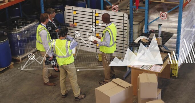 Reviewing board in warehouse, four workers in yellow vests pointing at notes, holding clipboard