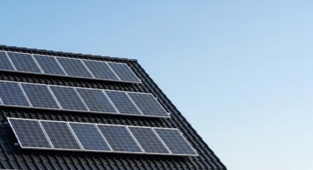 Fototapeta premium A solar panel array on a roof with a clear blue sky in the background.