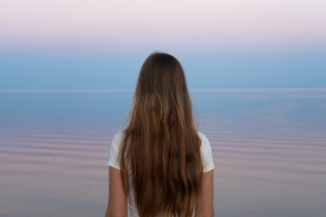 Obraz premium Girl gazes towards the horizon, her flowing hair reflecting a sense of freedom.