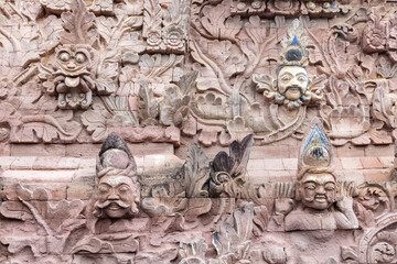 Stone sculpture artwork at the temple of Pura Beji Sangsit Temple in Singajara, Bali, Indonesia. The European faces depicted note the Dutch influence on Indonesian culture. 
