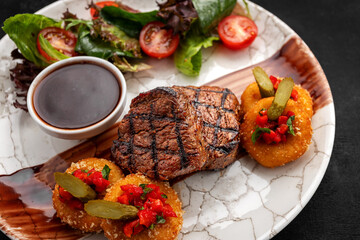 Veal medallions vegetables dark background