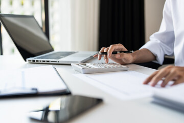 Businessman Saving money analyzing investment charts and pressing calculator buttons over documents. Accounting.