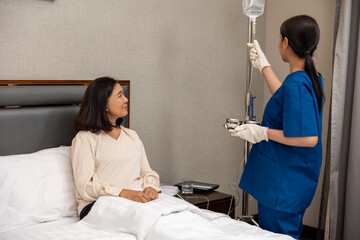 Female nurse attending a senior patient with an IV drip on a hospital bed, providing medical care and support during recovery, highlighting professional healthcare, bedside monitoring, and patient wel