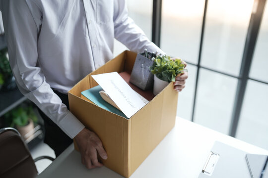 Business man sending resignation letter and packing Stuff Resign Depress or carrying business cardboard box Change of job or fired from company resign.