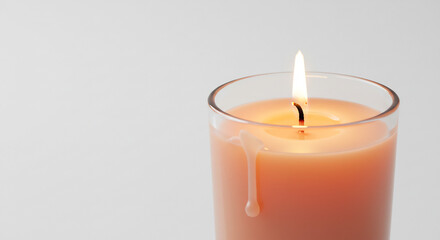 Warm glowing peach candle flame softly illuminates a minimalist white background a serene tranquil ambiance creating calm. AI Generated