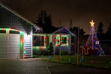 Beautiful Christmas decorations outside the house at night. House decorated with blue lights for Christmas