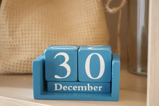 Wooden calendar displaying December 30 date on a shelf