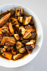 veggie stew bowl with roasted potatoes carrots zucchini and plant based chicken strips