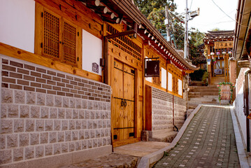 Seoul, South Korea, 11.02.2015: Bukchon Hanok Village. Vibrant flowers adorn a traditional house in Seoul, adding color and charm to the serene street view