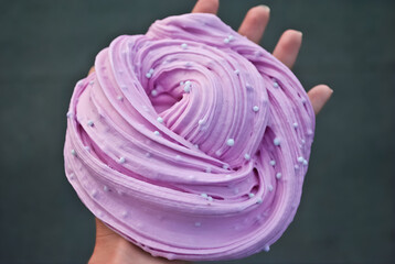 Hand Holding Swirled Purple Slime with Foam Beads, Close-up of Sensory Play Compound, DIY Stress Relief and Kid's Toy