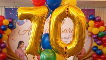 70th Anniversary Balloon Decoration - This video features a festive arrangement of balloons, dominated by large golden foil balloons forming the number 70, signifying a 70th anniversary celebration.