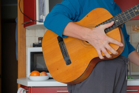 Man in Apartment Playing Guitar Human Hands Visible Instrument Man Standing in Hand Object