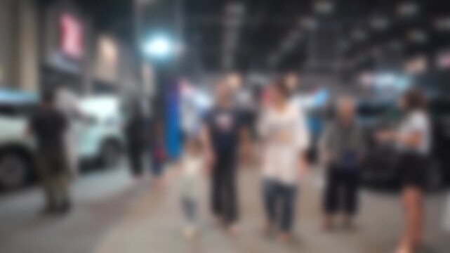 Car event held in a shopping mall. People walking around. Blurry and soft focus. There is slight camera shake.